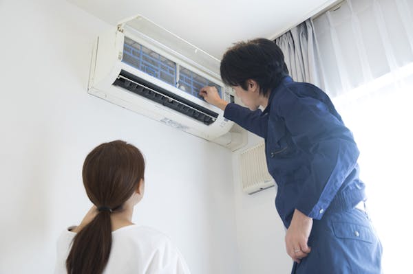 エアコン掃除を業者に頼んでいる様子