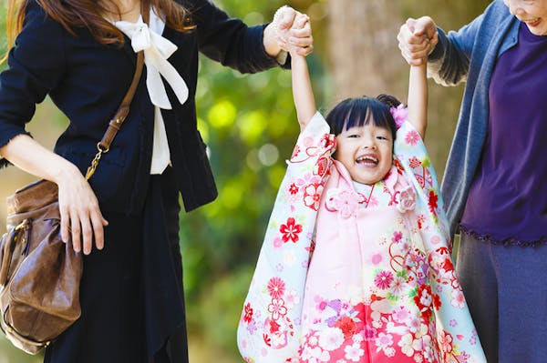 七五三で晴れ着を着る女の子と、その両親