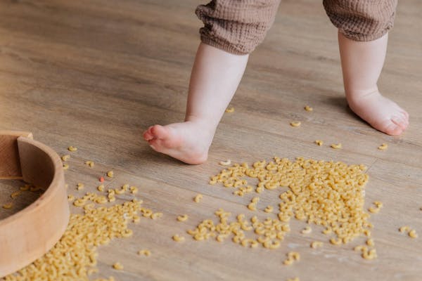 フローリングに食べ物をこぼした子供