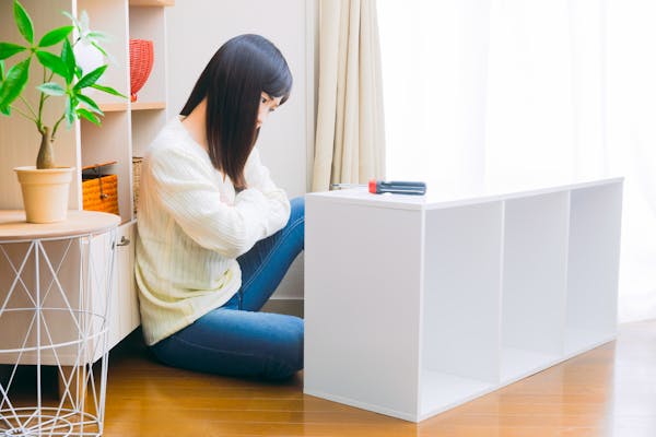 カラーボックスの使用方法を検討する女性