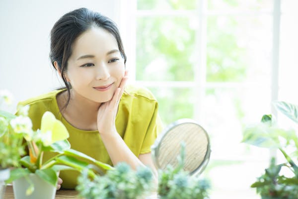 観葉植物を眺める女性