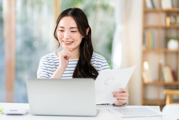 テレワークで書類を持つ若い女性