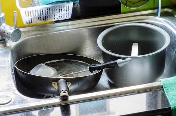 油まみれの調理器具とキッチンシンク